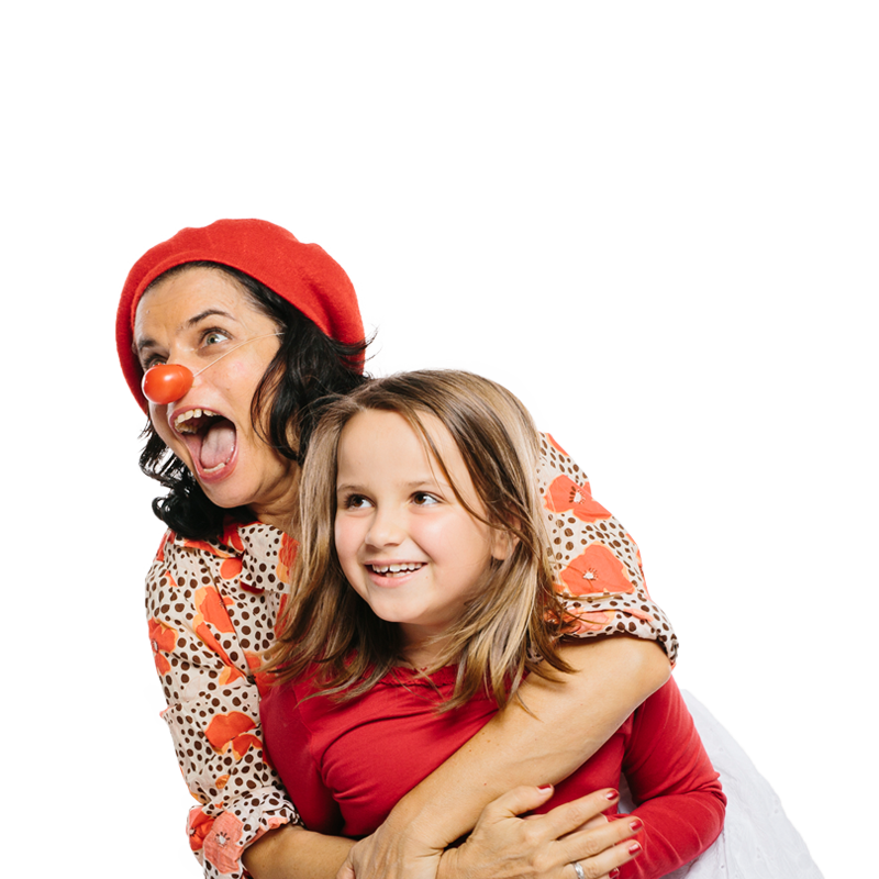 Clownin umarmt junges Mädchen von hinten, beide lachen